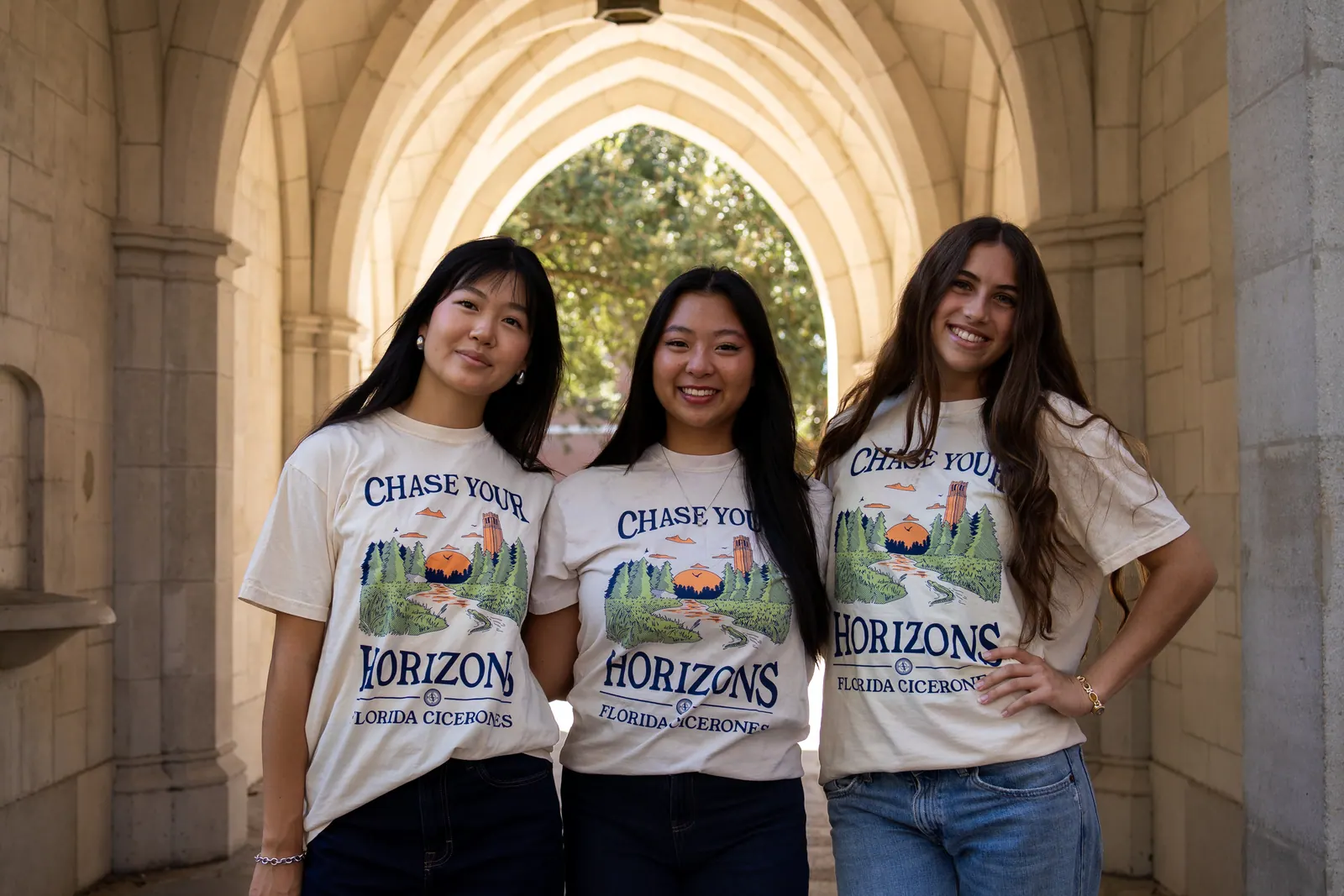 Three Florida Cicerones members smile in a vaulted stone corridor.