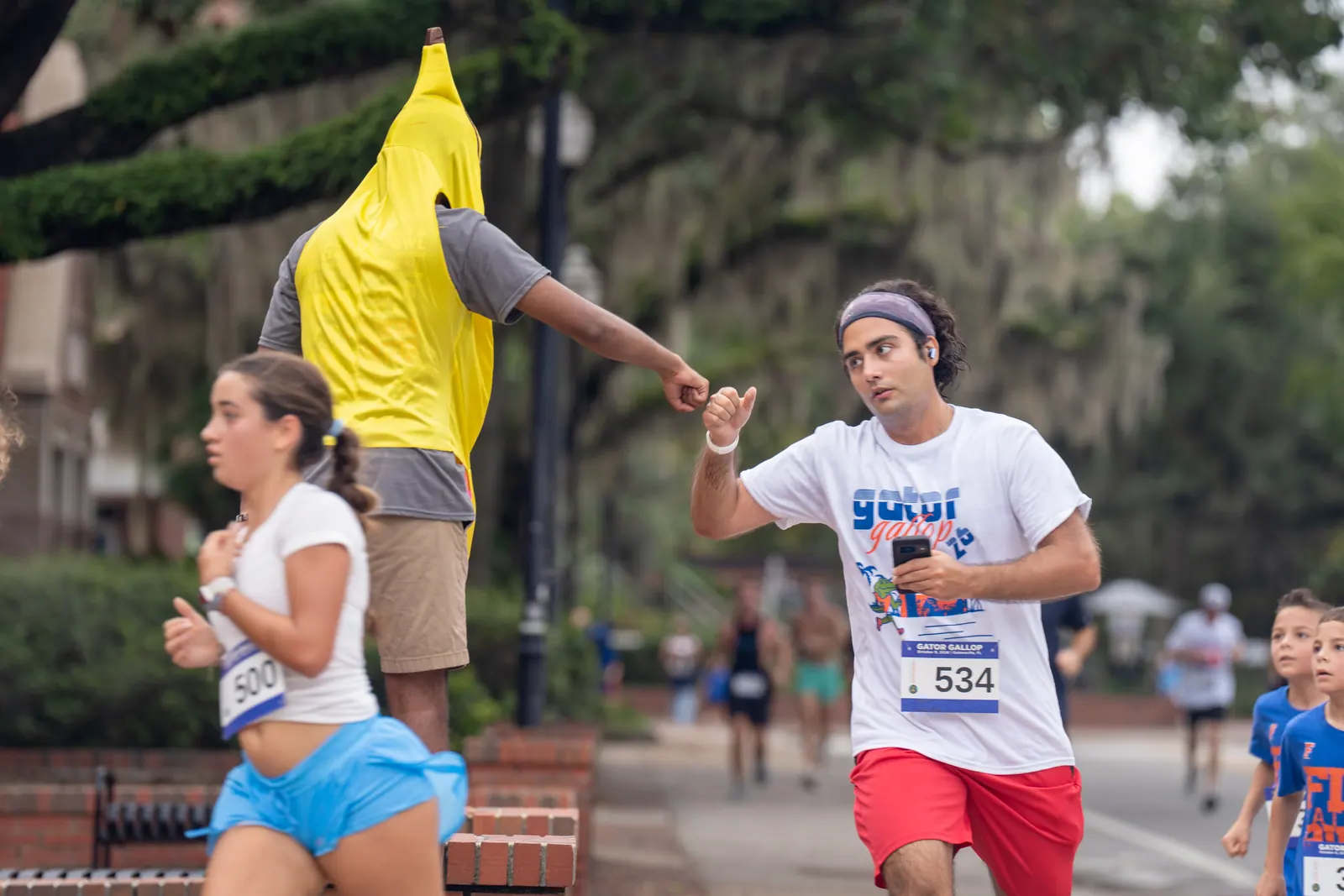 A runner high-fives a spectator in a banana costume along the course.
