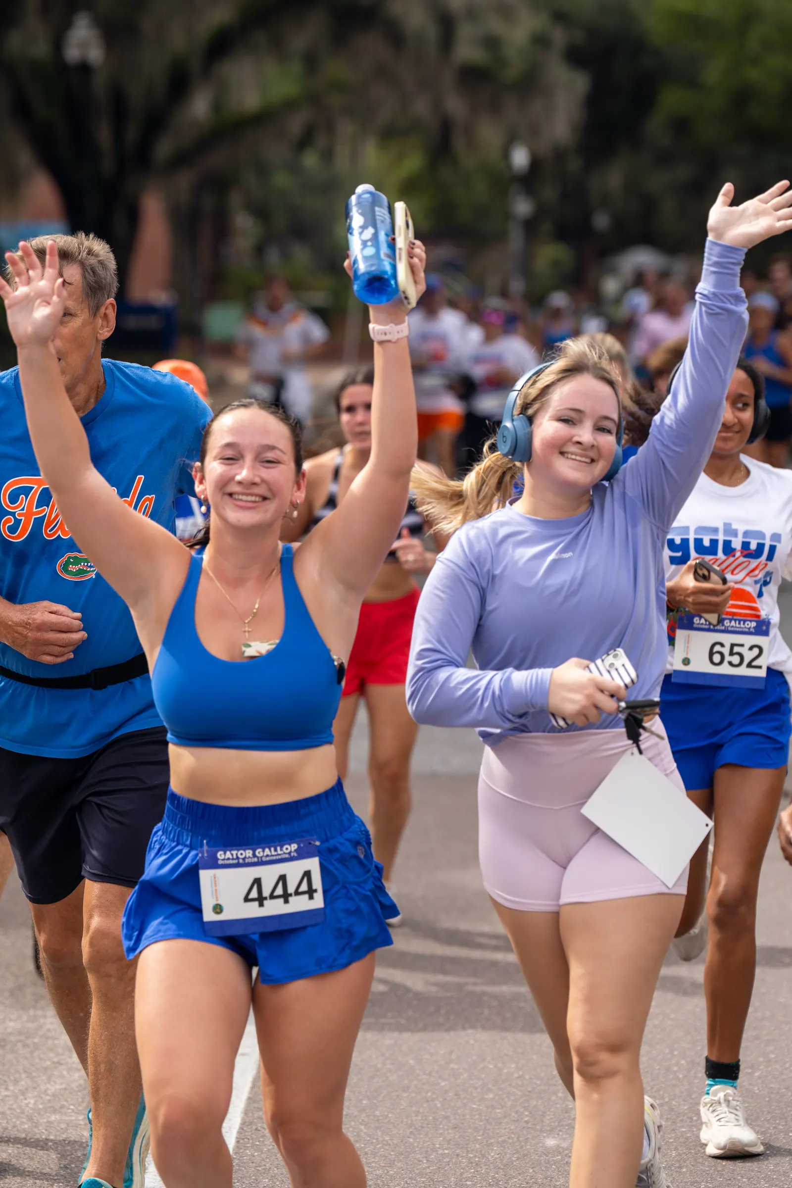 A group of runners cheers and waves as they head down the course.