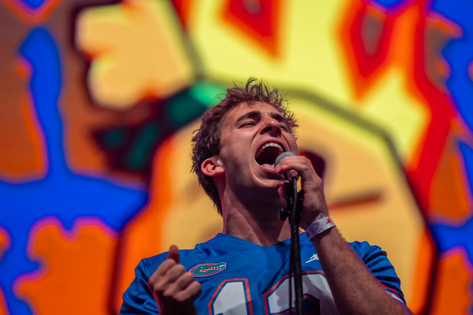 Petty Theft's vocalist in a Florida Gators jersey shouting into the microphone in front of a psychedelic video wall.